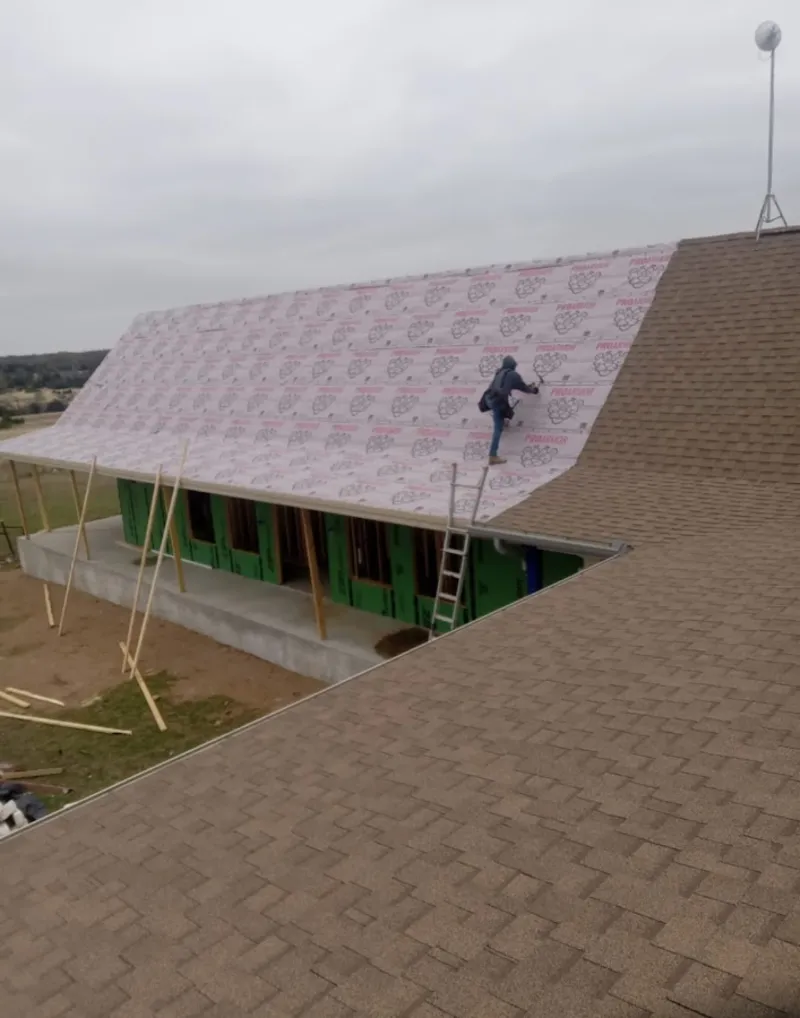 Worker preparing underlayment for a metal roof installation in Hockinson